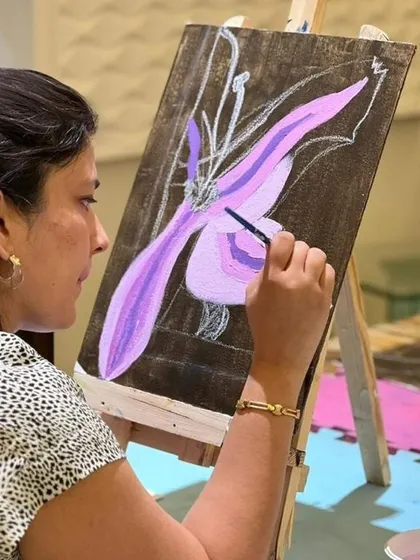 An adult artist finds her flow, painting a beautiful floral piece inspired by Georgia O'Keeffe. Our workshops for adults are designed to be relaxing, inspiring, and accessible to all skill levels.