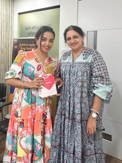 Here I am with a happy client at a clinic event. Building a personal connection and making my patients feel special is just as important as the treatments I provide.