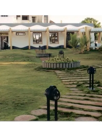 The landscaped garden of the CC Office in Tuticorin, featuring a stone pathway and a central planter. We designed the outdoor space as an extension of the building, creating a cohesive environment where architecture and landscape are one.