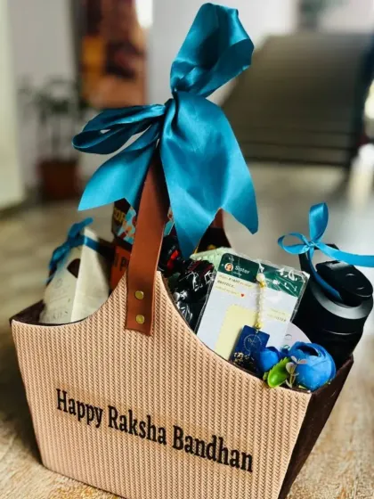 An indoor shot of the stylish "Happy Raksha Bandhan" tote bag, highlighting the rich blue ribbon.