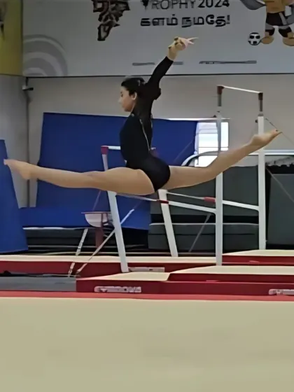 Capturing the power and precision of a leap during a competitive routine. This level of skill is what we strive for in our advanced artistic gymnastics training programs.