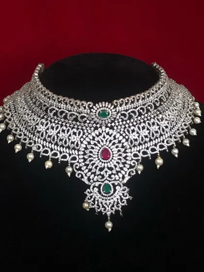 This wide CZ choker with ruby and emerald accents is a true statement piece. It's designed to sit beautifully on the collarbone and draw all the attention.