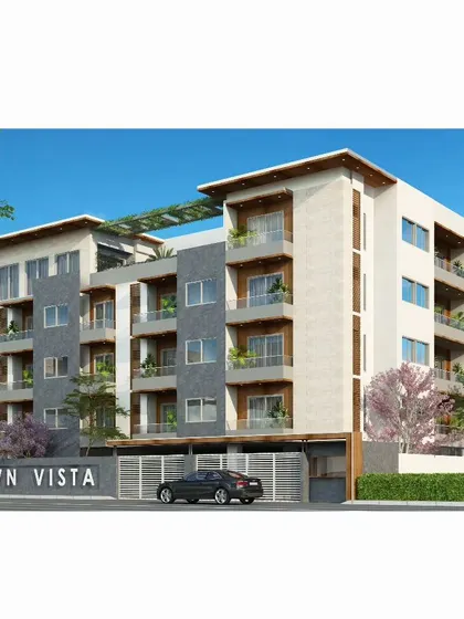The proposed day-view elevation for VN Vista premium apartments in Bangalore. The design features a clean material palette of white, grey, and wood, with spacious balconies for each unit.