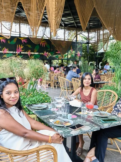 A group of friends enjoying a meal at one of our marble-topped tables in The Flame Tree zone.