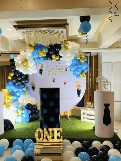 The Boss Baby theme is perfect for a little one who rules the house. This setup for Dhven's first birthday features character cutouts, a themed backdrop, and a professional blue, black, and gold color scheme.