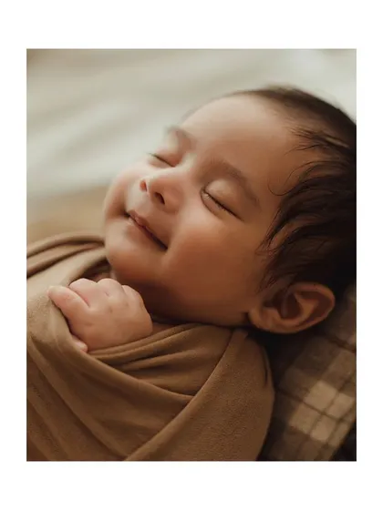 A sleepy newborn smile. Capturing these fleeting expressions is one of the most rewarding parts of a newborn session.
