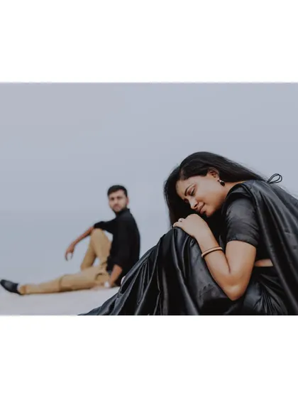 A wide shot of a couple in a minimalist black-themed pre-wedding shoot, emphasizing the feeling of space and solitude.
