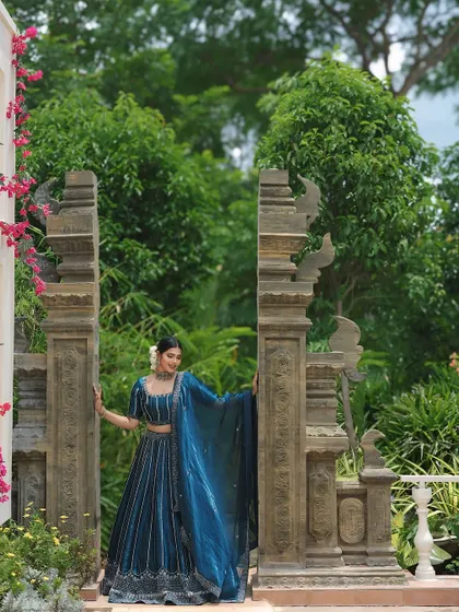 A stunning full-length shot in a beautiful garden setting. The makeup is balanced to look perfect with the grand lehenga.