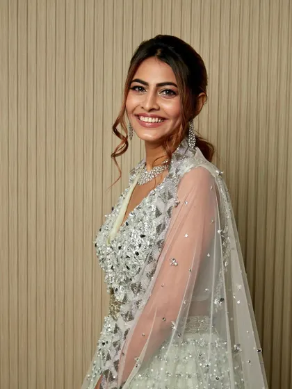 A full view of this stunning, shimmering lehenga and the complementary makeup. The entire look is designed to catch the light and sparkle from every angle.