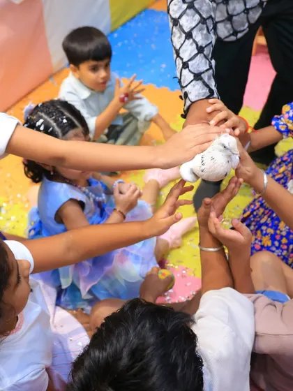 Children gently interact with a dove from the magic show. We ensure all animal interactions are safe, supervised, and positive for both the kids and the animals.