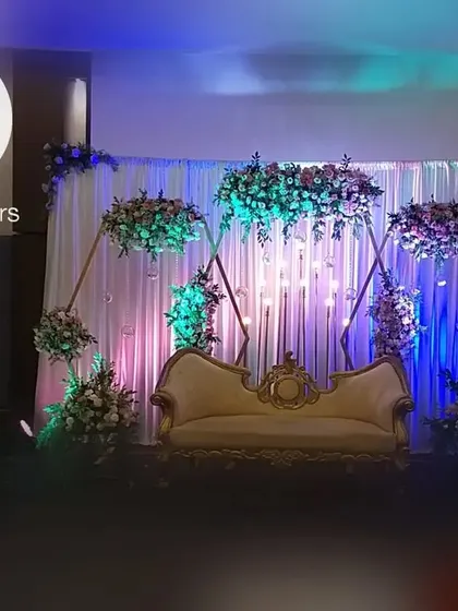 The complete anniversary party stage, combining the geometric backdrop, floral designs, and personalized ladder detail into one cohesive and beautiful setting.