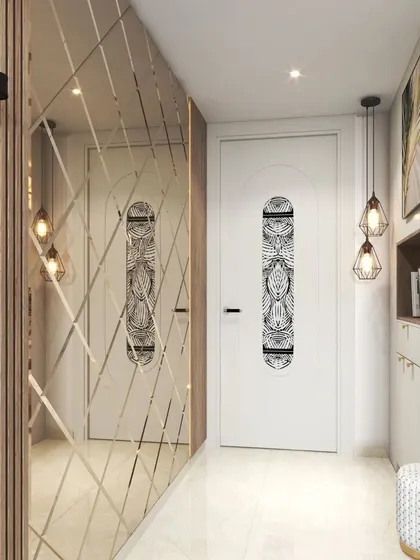 A glamorous entryway featuring a wall of diamond-patterned mirrors that creates a sense of space and light. The modern pendant lights add to the dramatic effect.