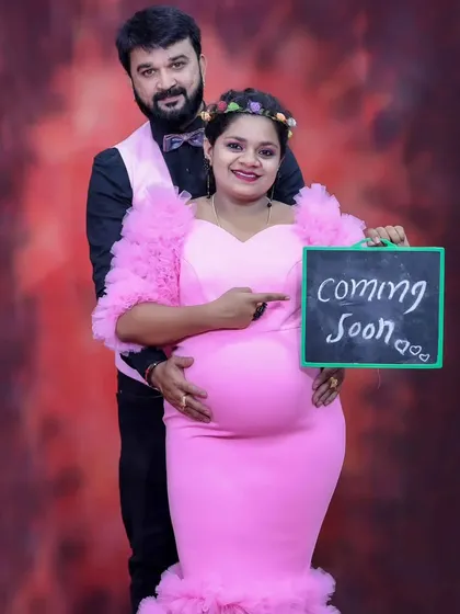 A sweet "coming soon" announcement photo, with the expecting couple holding a small chalkboard sign.