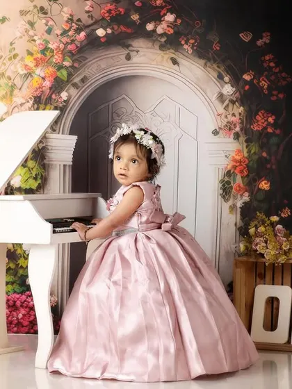 A little pianist in her beautiful pink gown. This enchanting setup with a floral arch and a miniature grand piano is perfect for a fairytale first birthday.