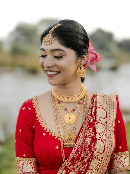 A close-up of the bride's happy, smiling face. Her makeup is fresh and natural, perfect for an outdoor photoshoot.