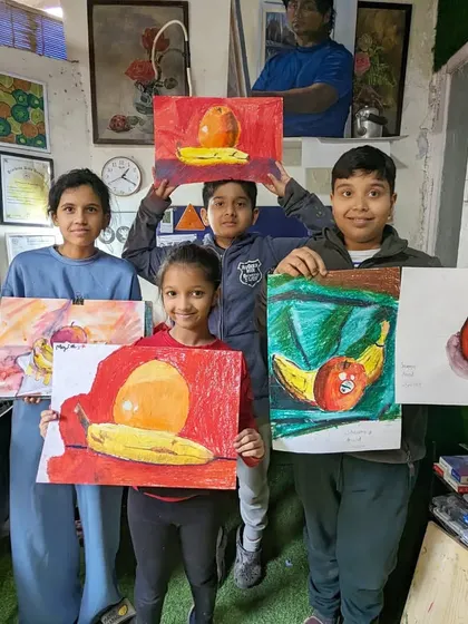 A group of our younger students showing off their still life paintings of fruit. We teach them how to see and draw simple forms, understand color relationships, and compose a balanced image.
