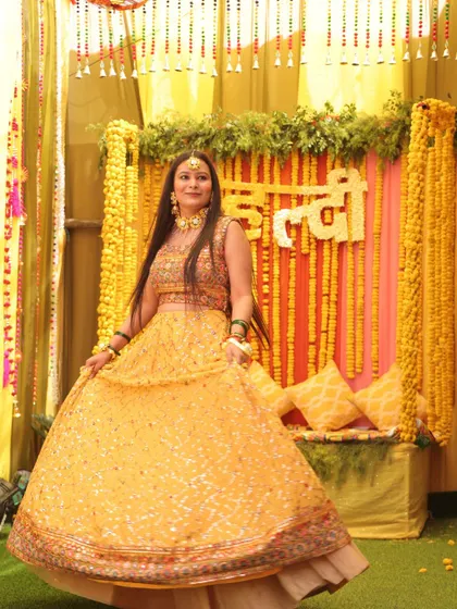 This is a traditional Haldi setup we created, featuring a backdrop of marigold strings and a custom floral sign. The decor is designed to complement the joyful rituals of the ceremony, providing a beautiful setting for the bride.