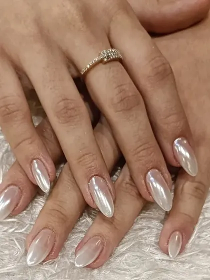 A stunning set of pearlescent chrome nails. This "glazed donut" finish on long almond nails provides a clean, elegant, and highly fashionable look that is perfect for any occasion.