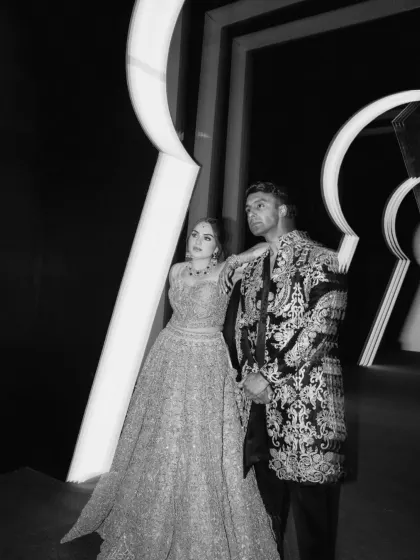 A chic, black-and-white portrait of the couple at the keyhole entrance. The dramatic lighting and structure create a stunning, high-fashion photographic moment.