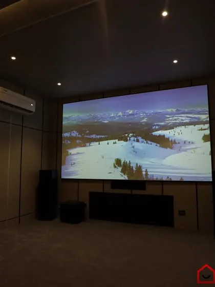 A 7.1.4 Dolby home cinema with a clean, minimalist design, featuring light-colored acoustic panels and floor-standing speakers.