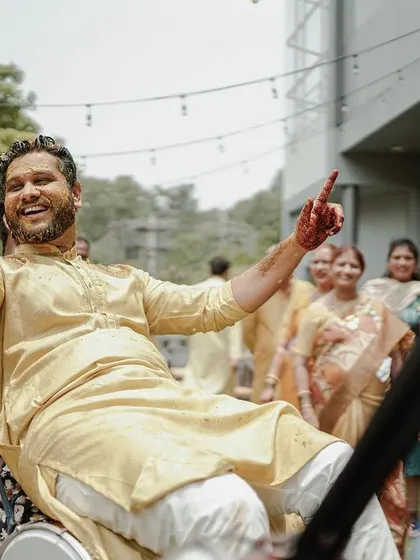 The groom is lifted up in celebration during his Haldi ceremony, a moment of pure joy and excitement.
