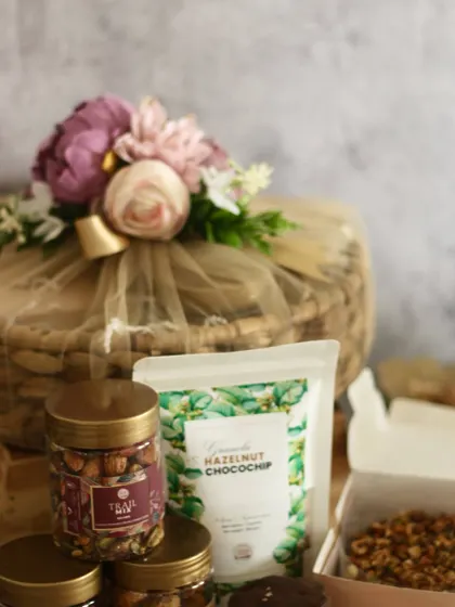 The Vrudhi Basket Hamper is one of our most abundant offerings. It includes a tea cake, granola, cookies, cookie bites, mukhwas, nuts, trail mix, chocolates, and a diya in a reusable basket.