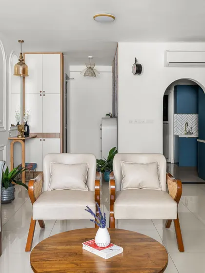 A view from the center of the living room, looking towards the entryway and the bold blue kitchen. The archways create a beautiful sense of flow and connection between the spaces.