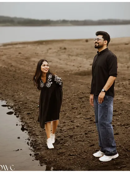 A fun and quirky pose by the water's edge, showing the couple's playful personalities during their pre-wedding shoot.