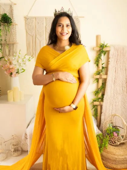 A classic portrait in a bright yellow gown, with a crown for a touch of royalty. The boho setup adds a layer of warmth and texture.