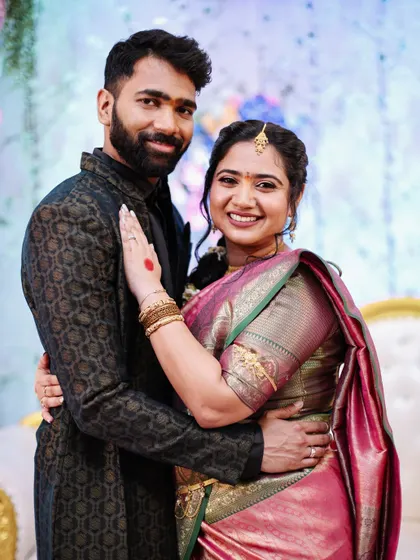 A warm portrait of an engaged couple embracing and smiling at the camera.