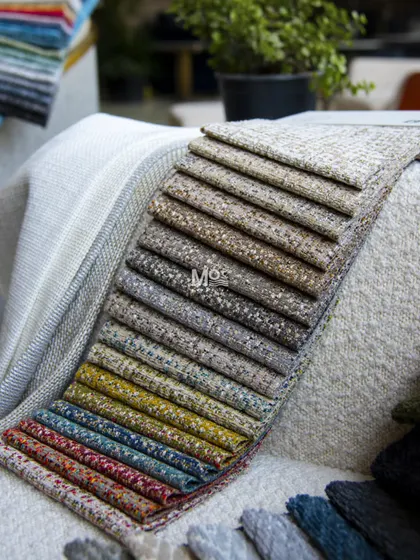 A full swatch book of our textured fabrics, fanned out to display the wide variety of colors and weaves we offer for creating customized moodboards and designs.
