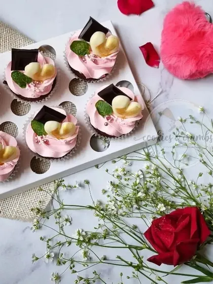 A box of six pretty-in-pink cupcakes for Valentine's Day. These are topped with pink frosting, dark chocolate, and white chocolate hearts.
