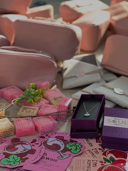 A flat lay of some of the beautiful items included in the Women's Day hampers, such as the evil eye necklace from Soul, scented soaps, and a personalized pouch.