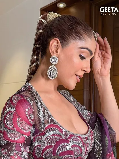A side profile of our modern bridal hairstyle. The intricate, wrapped ponytail is a unique and stylish choice for a bride who wants to make a statement, while the makeup remains soft and glowing.