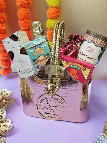 Our personalized metallic bag hamper for Diwali. The bag can be customized with a name and is filled with premium snacks and a non-alcoholic champagne.