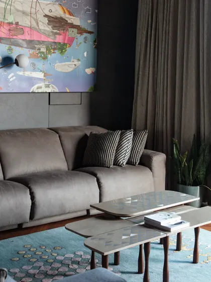Another view of the family lounge, highlighting the layered textures and art. The custom coffee art table and luxurious 'Kolam' rug from Jaipur Rugs create a comfortable yet stylish environment.