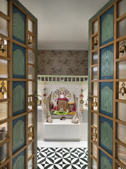 The puja room in the Slender House is a quiet area for reflection. The bespoke temple door, with its arch design and brass bells, adds to the serene atmosphere.