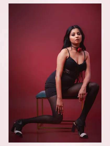 A glamorous and dramatic studio portrait. The rich red background and the model's pose create a sense of intimacy and intensity, perfect for a beauty or fashion editorial.