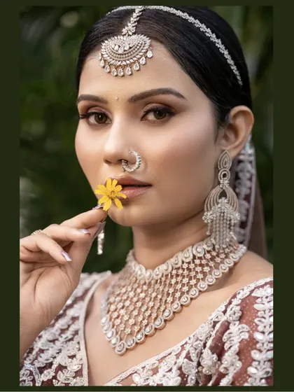 A modern bridal portrait with a touch of tradition. The bride holds a yellow flower, adding a pop of color that contrasts beautifully with her diamond jewelry.