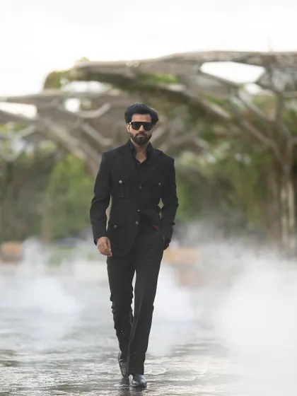A powerful walking shot in the black Viaggio Blazer, with a misty backdrop adding to the drama.