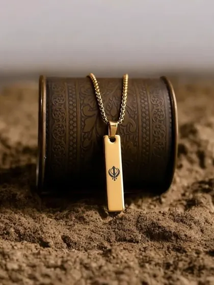 This gold bar pendant is engraved with a Khanda symbol, showing my ability to customize pieces with meaningful religious or cultural symbols.