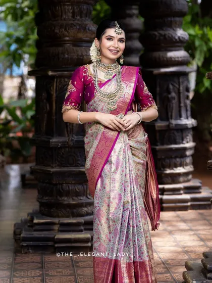 A full-length view of the bride, showing how the silver-finish jewellery stands out against the pink and cream saree.