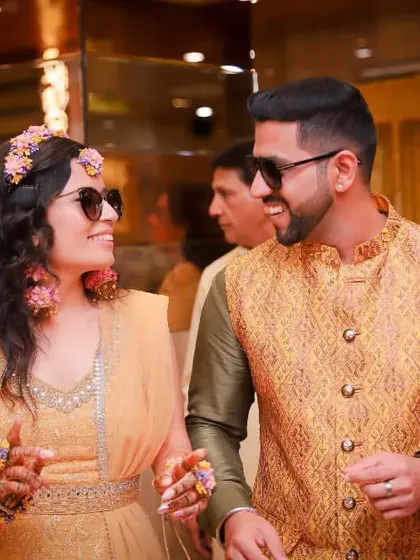 A great candid shot of the couple enjoying their Haldi celebration. Their matching sunglasses and big smiles show they are having the time of their lives.