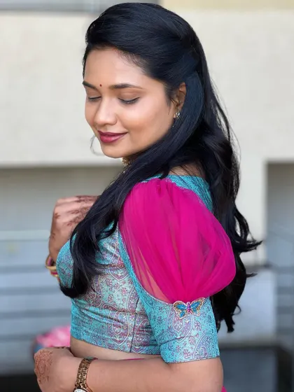 A close-up of a unique blouse design, featuring a printed blue fabric with dramatic pink puff sleeves.