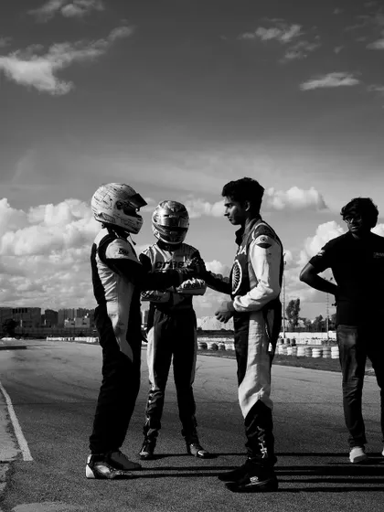 A black and white photo of teammates showing sportsmanship on the track.