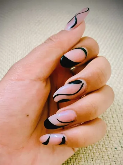 We love playing with abstract lines. This design uses fine black swirls and blocks on a sheer nude base for a modern, artistic, and minimalist manicure.