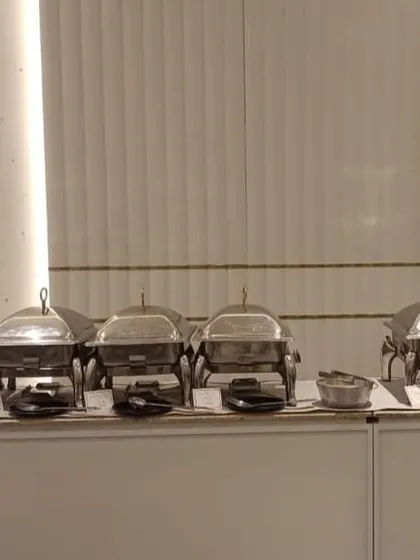 A neat row of chafing dishes set up in a party hall at Prestige Finsbury Park, ready for a house party.