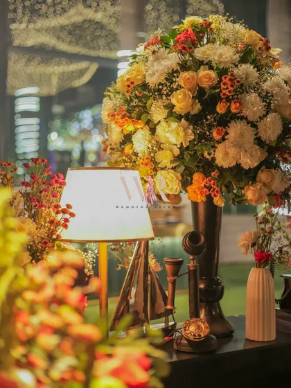 The soft glow of a table lamp illuminates a beautiful floral arrangement and a collection of vintage props. I love creating these small, interesting corners that invite guests to look closer.