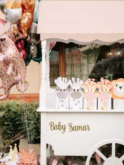 A detail of the party favors cart, with adorable jungle-themed gift bags and animal-shaped foil balloons ready for the guests.