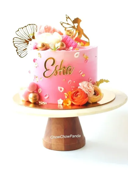 A clear, straight-on view of the angel-themed floral cake.